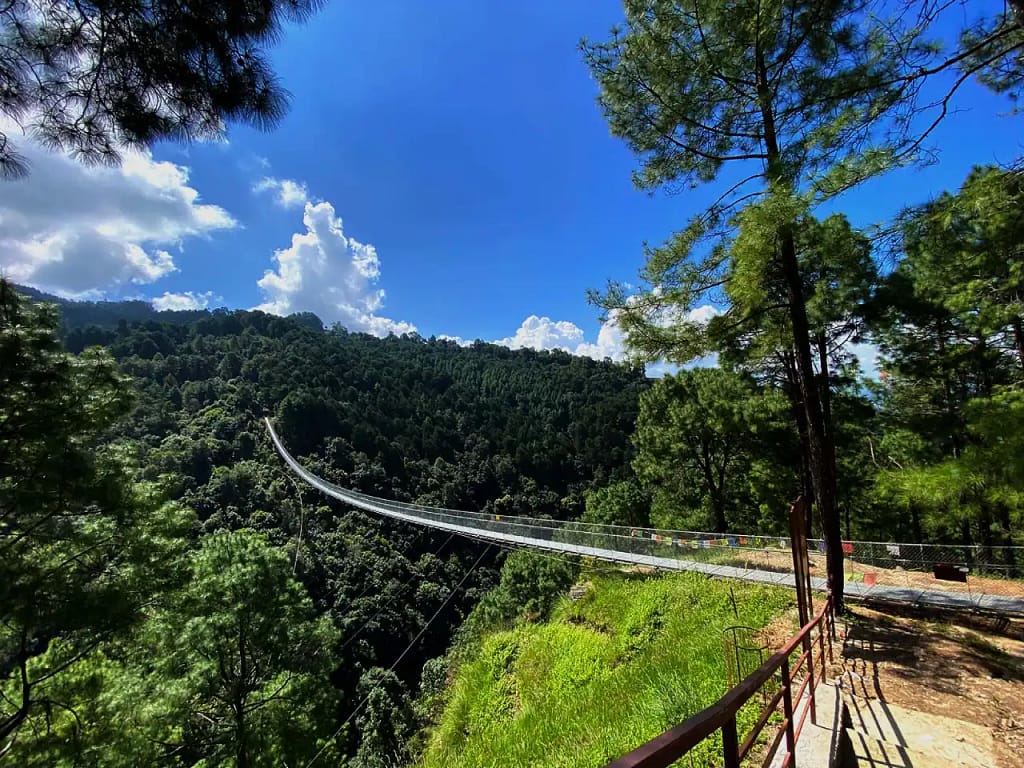 Suspension bridge and green forest on a guided hiking route near Nagarkot, Nepal