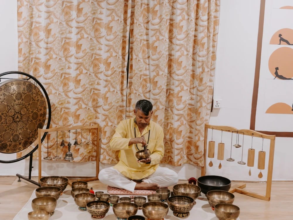 Sound healing teacher conducting a singing bowl session at a yoga retreat in Nepal